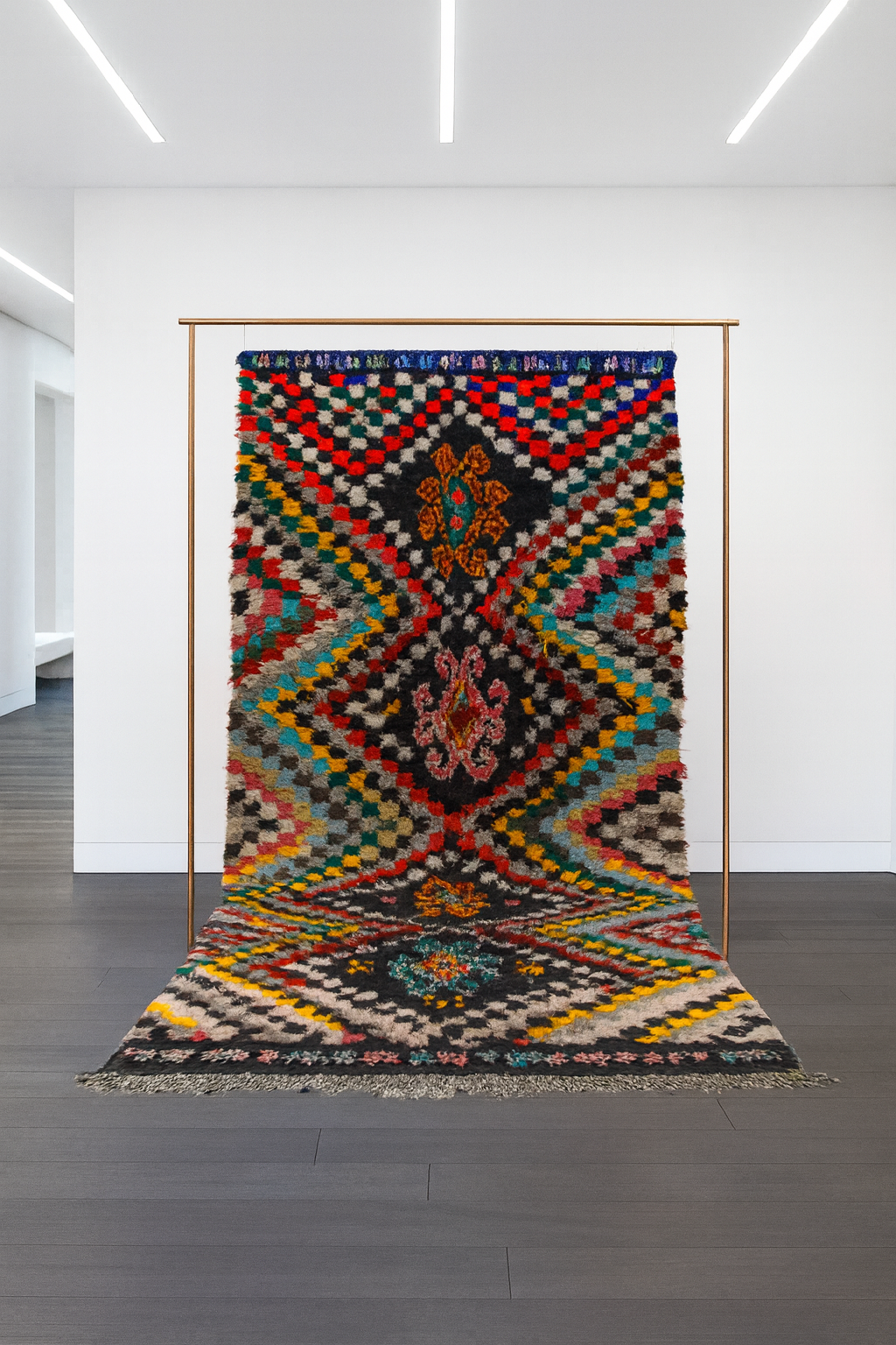 Colorful Boucherouite rug made from fabric scraps and wool, featuring bold geometric patterns in a bright living room setting.
