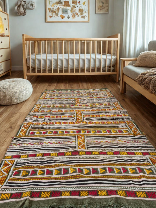 Nursery room with wooden crib, patterned rug, and wooden floor.