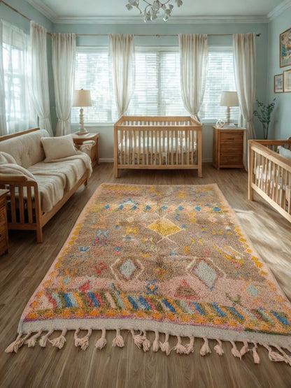 Nursery room with wooden crib, sofa, and colorful rug.