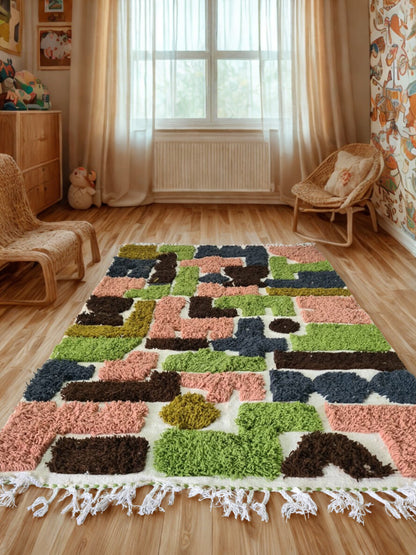 Colorful geometric-patterned rug on a wooden floor with wicker furniture and curtains in the background.