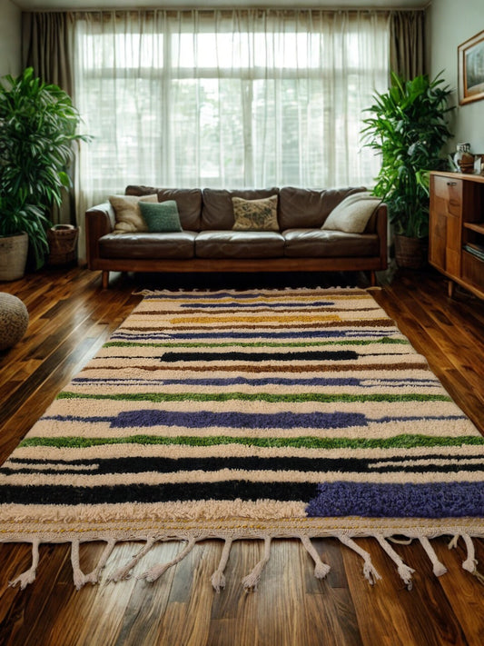 Living room with a colorful striped rug, brown sofa, and plants.