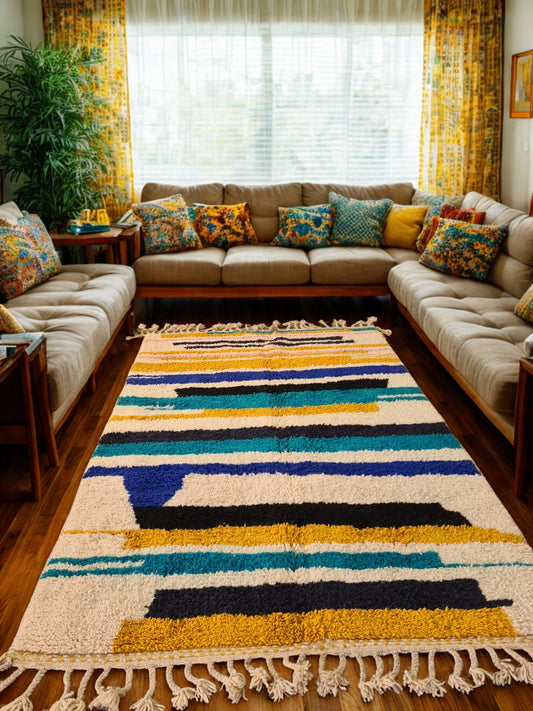 Living room with a colorful striped rug, beige sectional sofa, and patterned cushions.