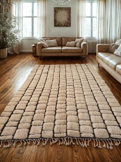 Beige checkered rug on a wooden floor with beige sofa and curtains in the background