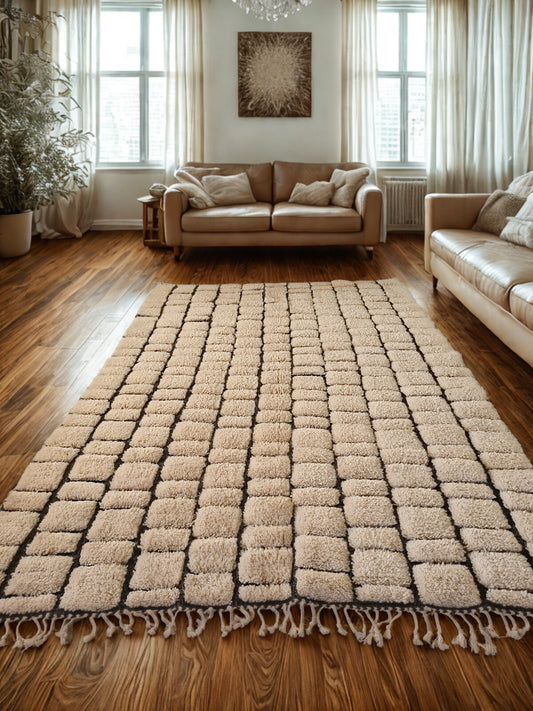 Beige checkered rug on a wooden floor with beige sofa and curtains in the background