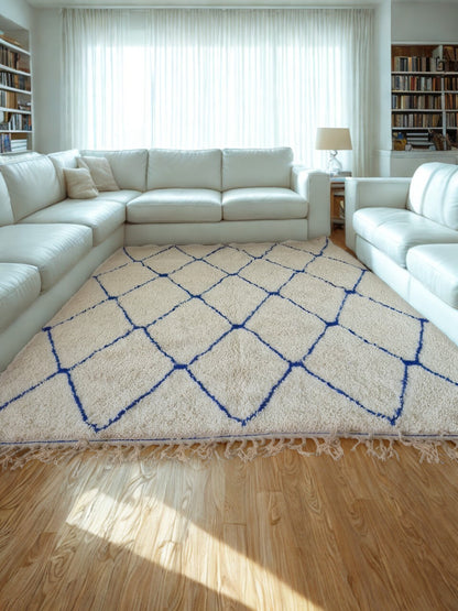 Living room with a white sectional sofa and a patterned rug on a wooden floor.