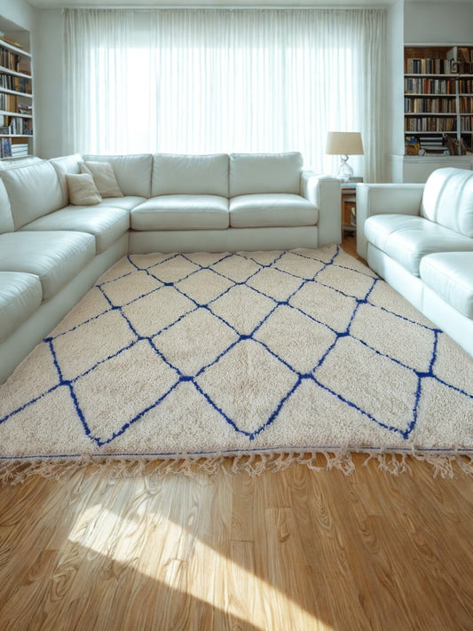 Living room with a white sectional sofa and a patterned rug on a wooden floor.