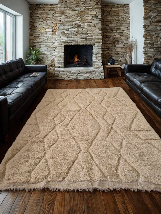 Living room with stone fireplace, black leather sofa, and patterned beige rug.
