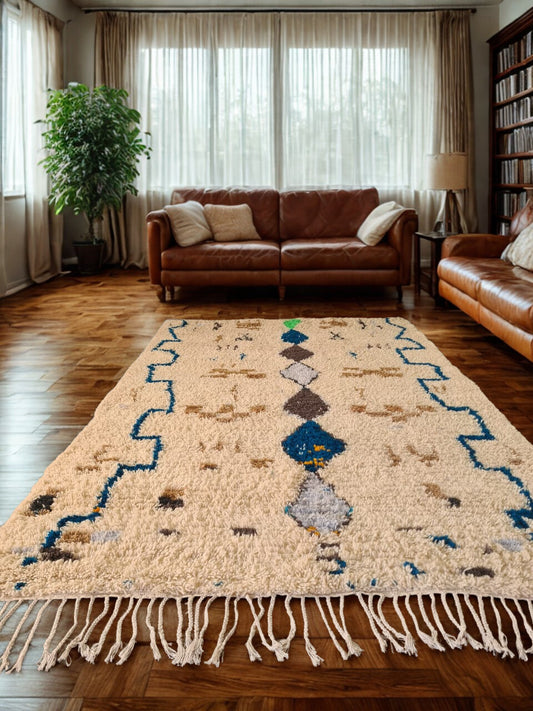 Living room with a patterned rug, brown leather sofa, and bookshelf.