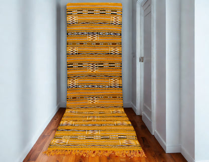 Yellow patterned rug on a wooden floor in a room with white walls.