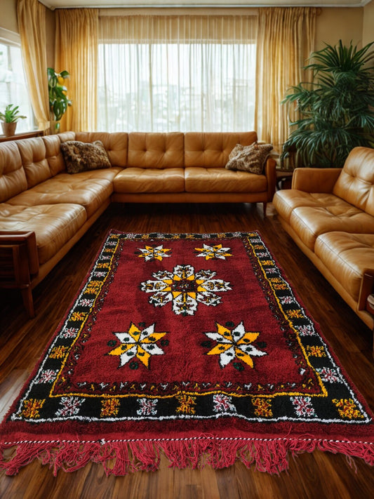 Living room with brown leather sectional sofa and a colorful patterned rug.