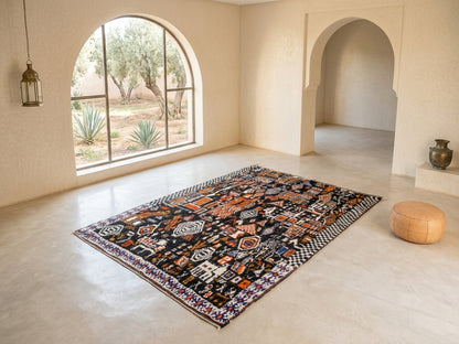 A rectangular area rug with a complex multicolor geometric and tribal pattern, displayed on a light beige stone floor in a minimalist, modern Moroccan-style room with arched windows and walls.
