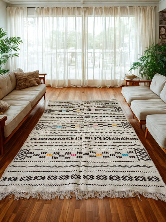 Living room with a patterned rug, beige sofa, and wooden coffee table.