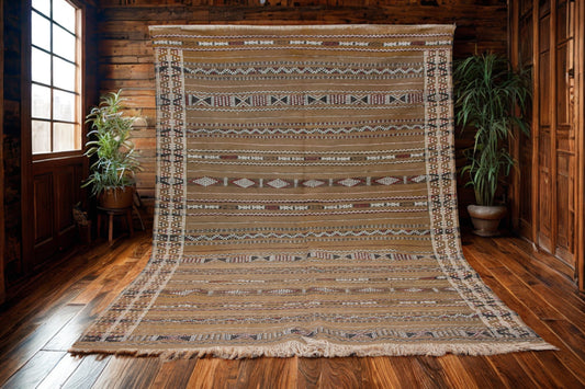 Patterned rug on a wooden floor with plants and wooden walls in the background