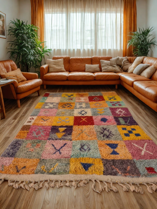Living room with a patterned rug, brown leather sofa, and plants.