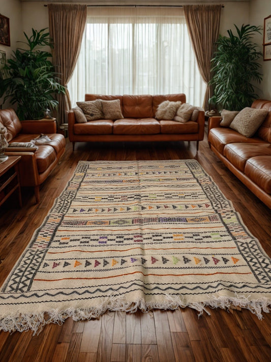 Living room with brown leather sofas and a patterned rug on wooden floors.