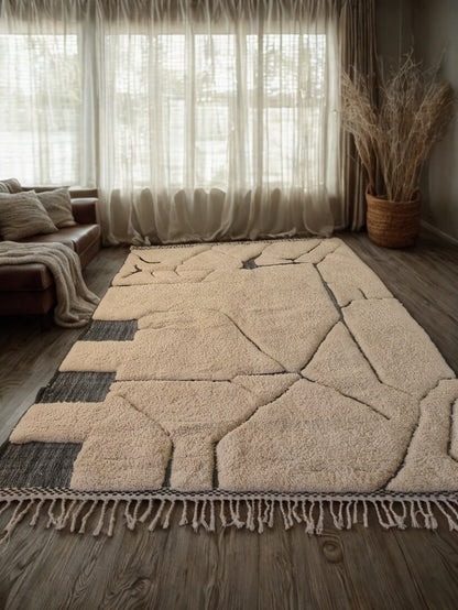 Beige geometric patterned rug on a wooden floor with a living room setting.