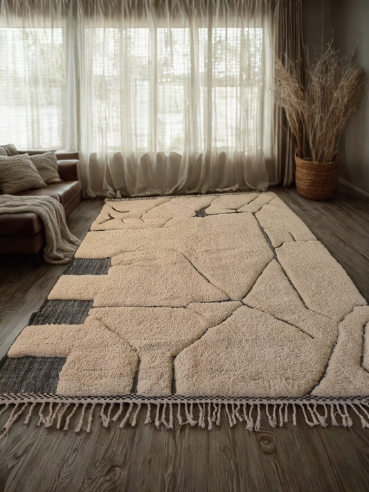 Beige geometric patterned rug on a wooden floor with a living room setting.